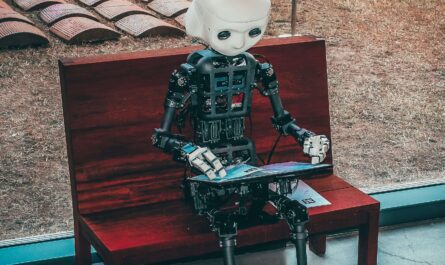 A humanoid robot sitting on a bench using a digital tablet, symbolizing the role of AI in design