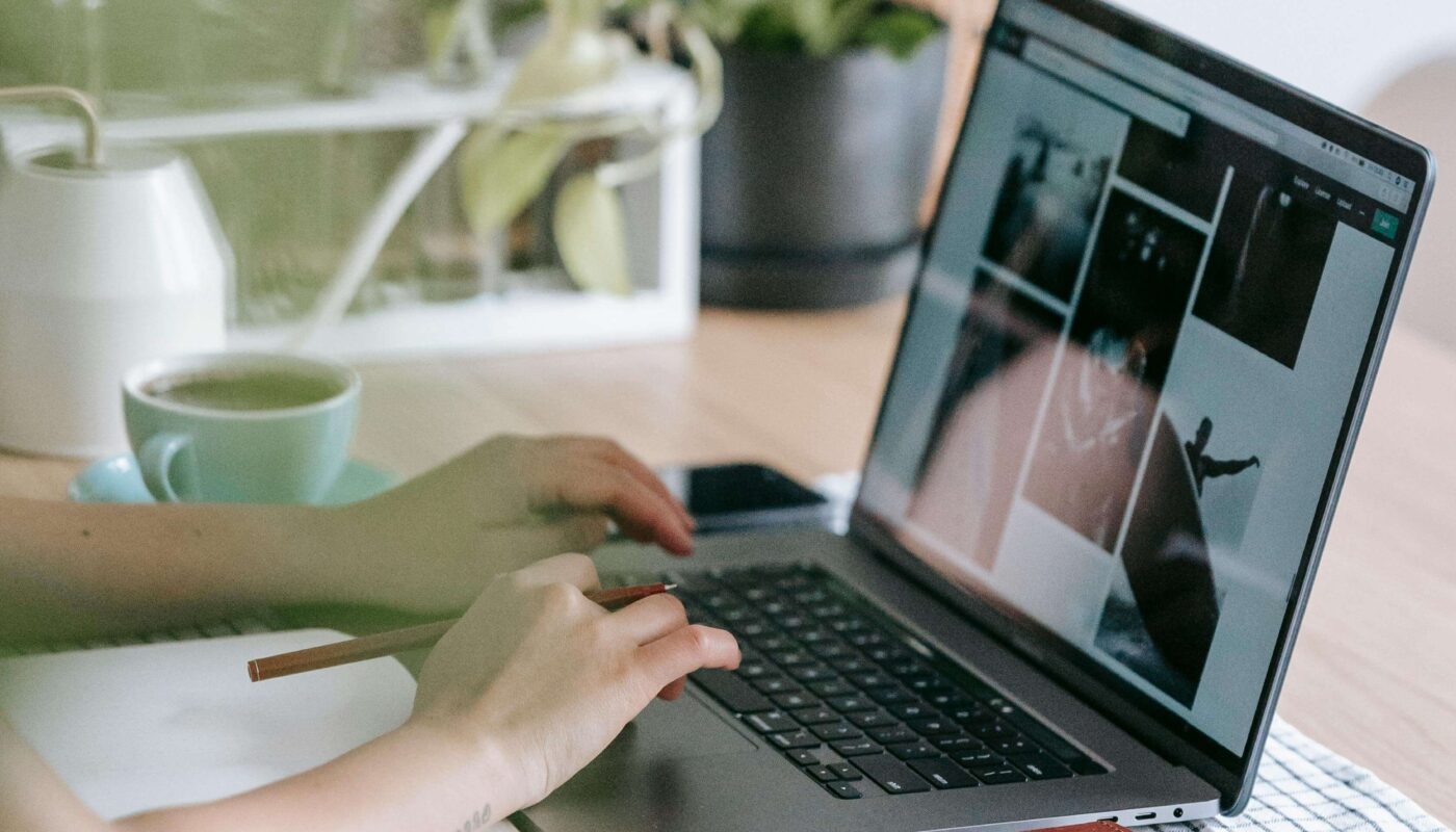 Person designing a logo using AI tools on a laptop in a modern, bright workspace—perfect for product designers.