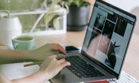 Person designing a logo using AI tools on a laptop in a modern, bright workspace—perfect for product designers.